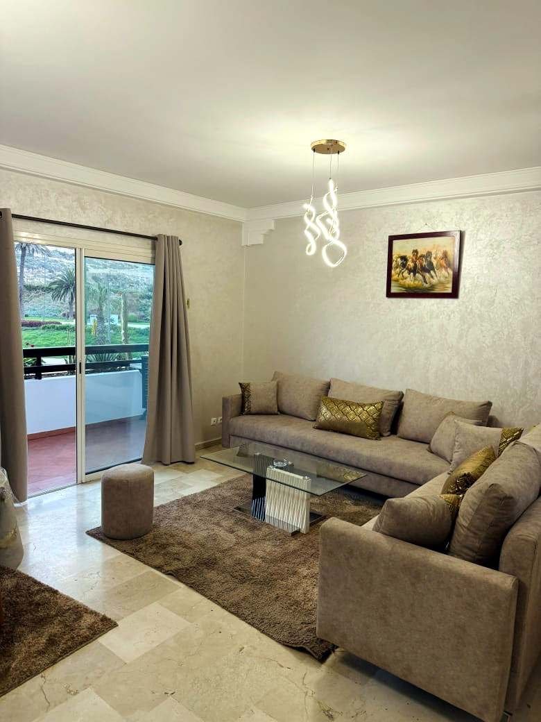 Appartement 1 chambre, salon beige et balcon